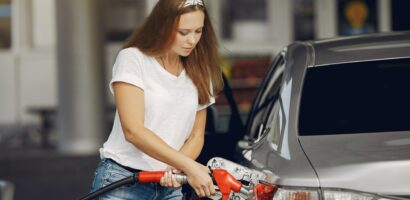 Young woman pumping gas